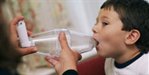 Boy being shown how to use volumatic inhaler