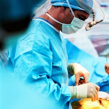 Surgeon performing op (side view close)