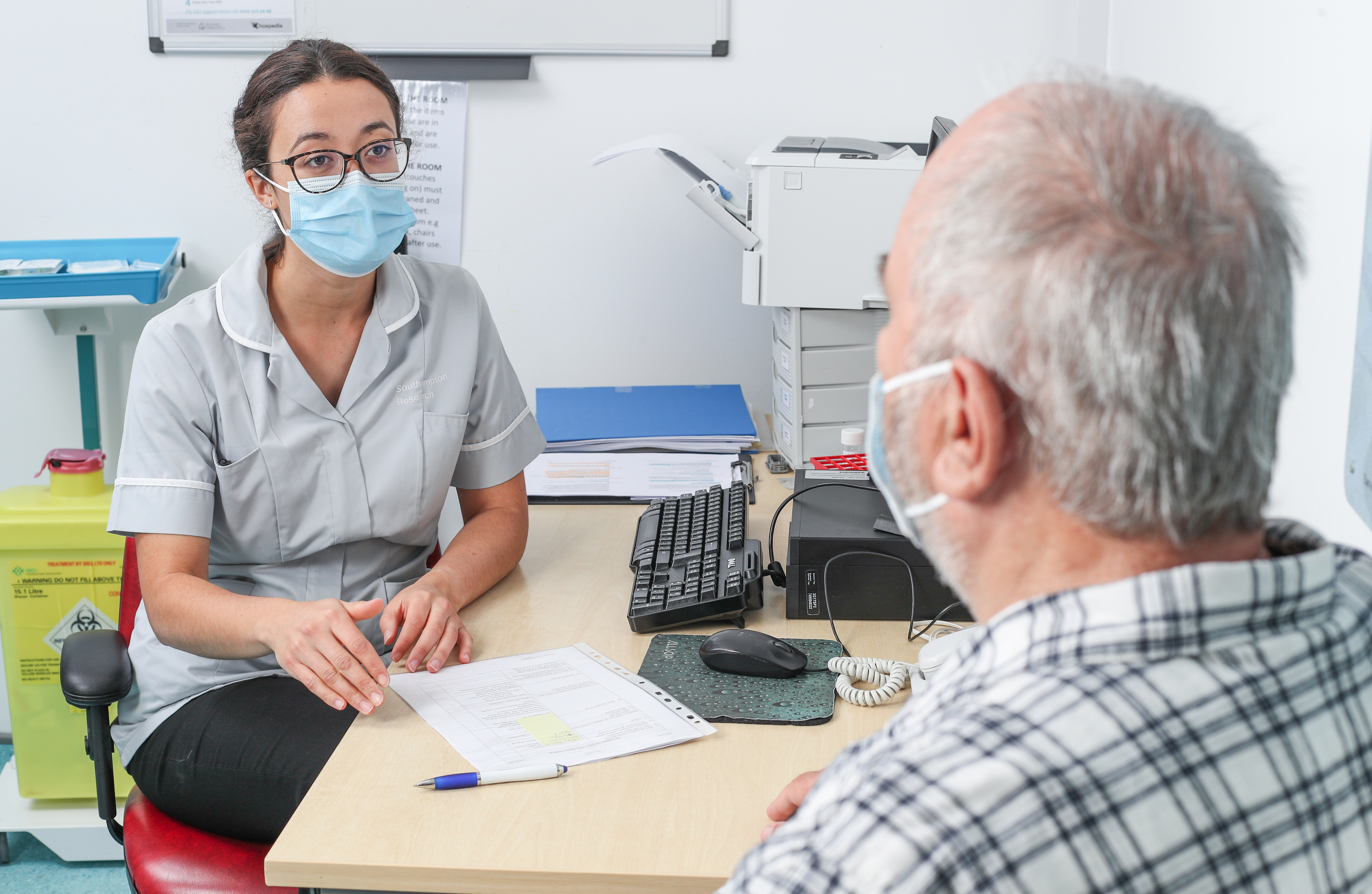 Research member of staff talking to a patient