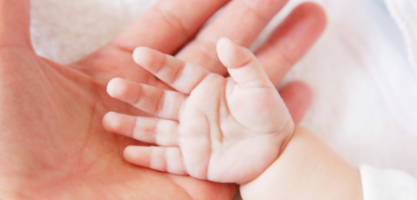 A baby's hand against an adult's