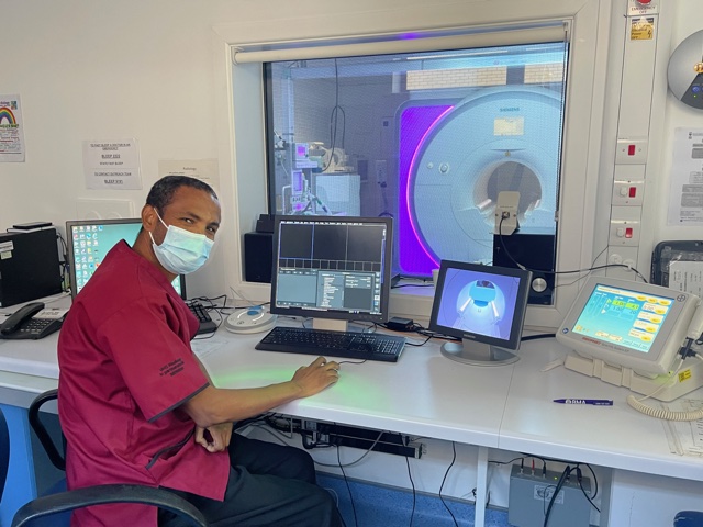 Member of radiology staff with scanning equipment