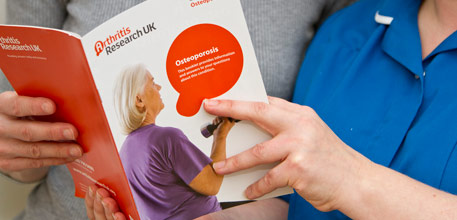A patient and member of staff looking at an information booklet.