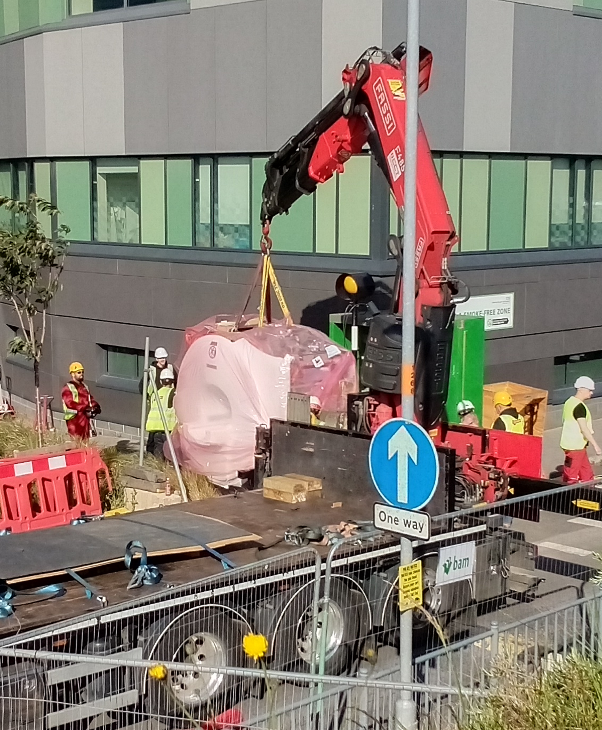 Large magnet being craned off the back of a flatbed lorry.