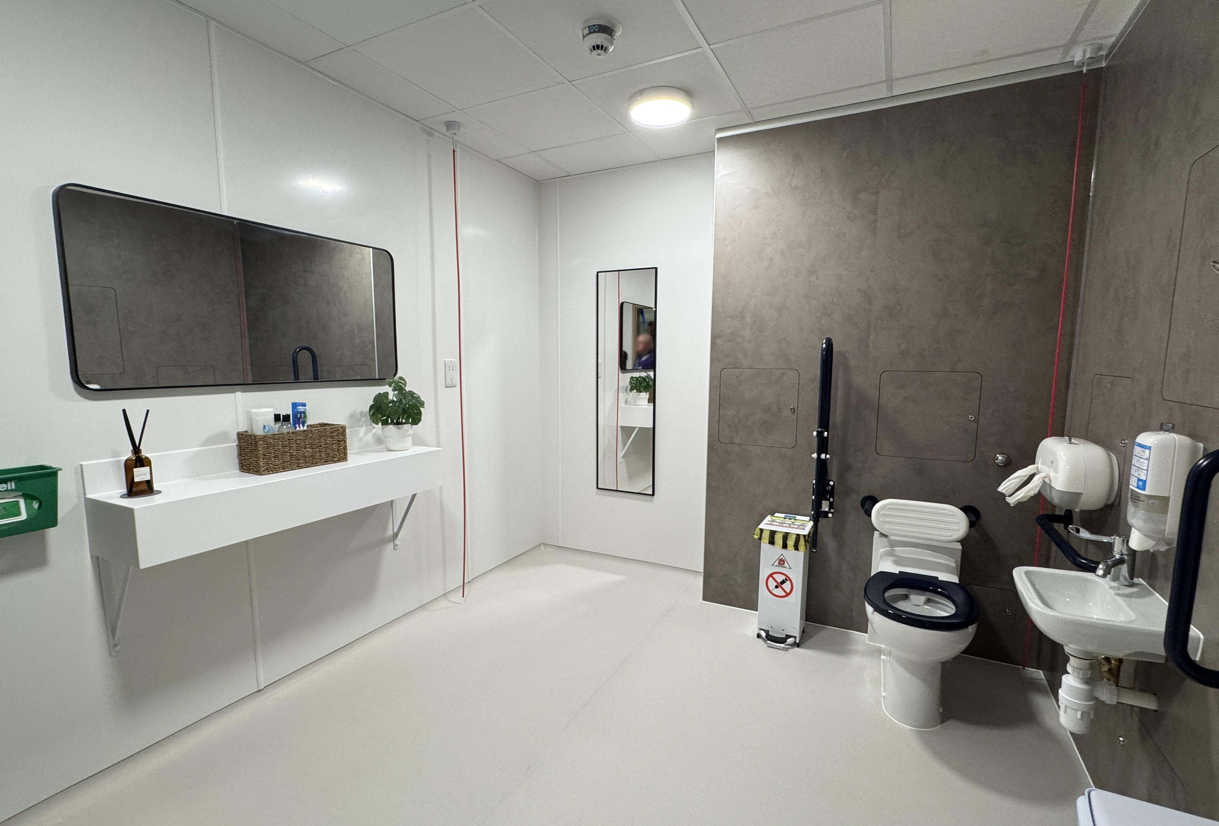 Large spacious shower room with mirror and toilet.