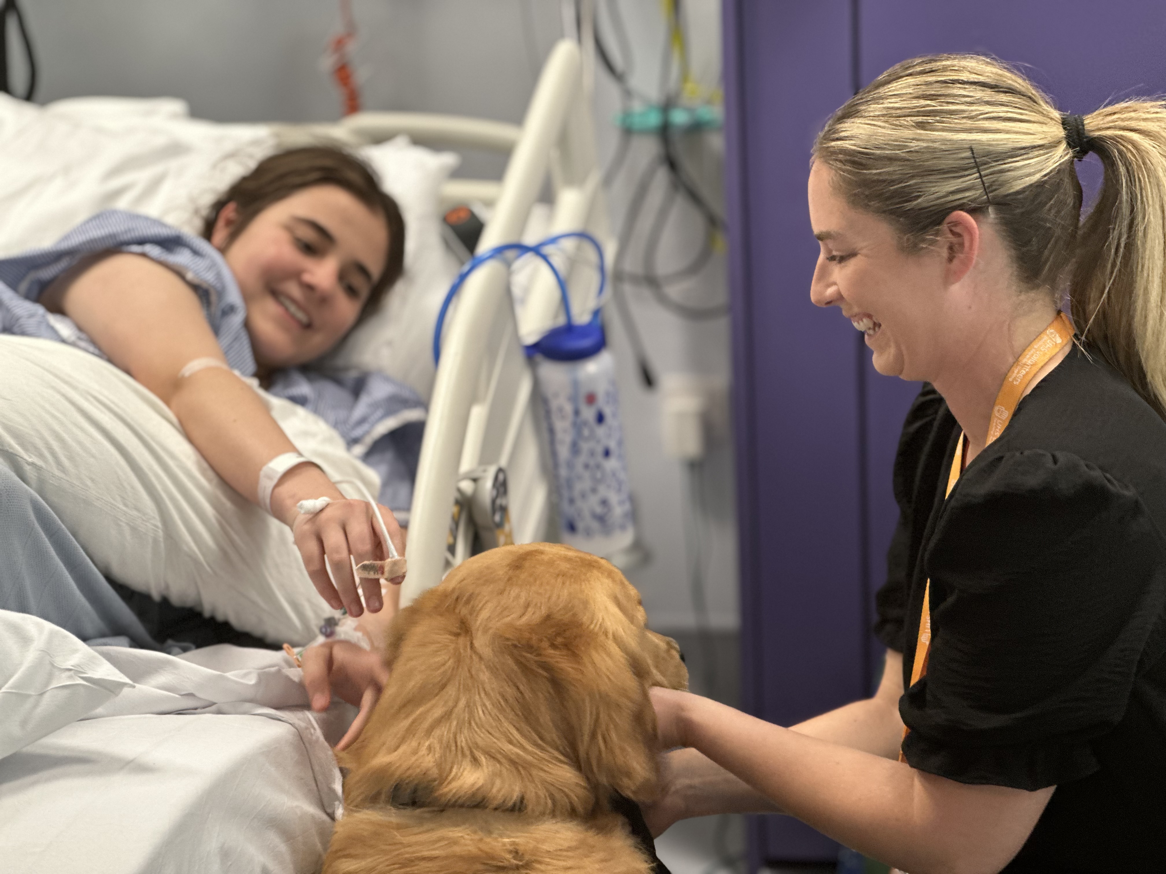 Picture shows Barney on a visit to a patient's bedside, supervised by volunteer, Emily Lowther.